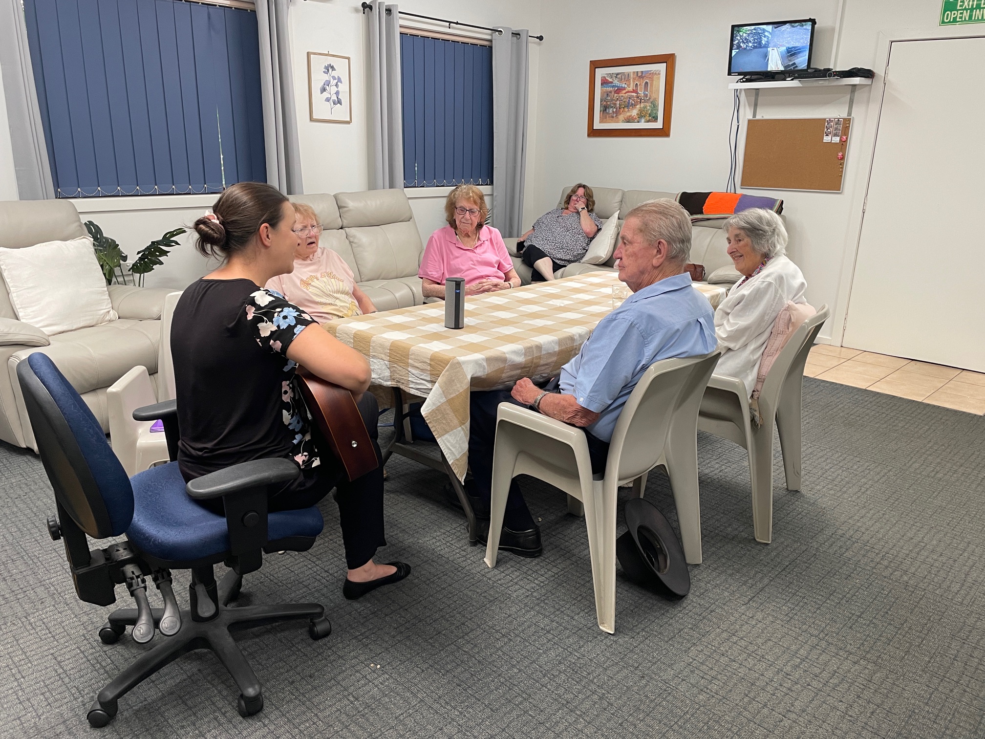 Registered Music Therapist running a group session with aged care residents seated around a table